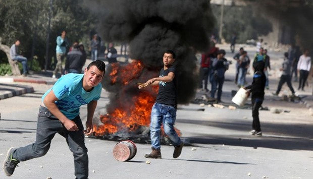 Palestinian demonstrators hurl rocks during clashes with Israeli border guards in the village of Araka, west of Jenin, in West Bank on Monday.