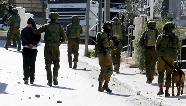 Israeli soldiers arrest a stone-throwing Palestinian during clashes in al-Amari refugee camp