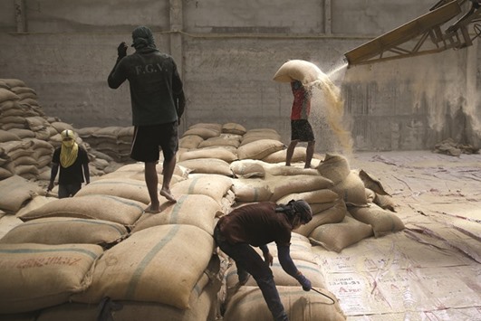 Workers unload sacks of rotten rice at a warehouse in Ratchaburi province. Thailand yesterday reported economic growth of 2.8% in 2015, against 0.8% in 2014.