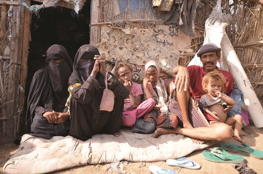 A family poses for a photo in their hut in a slum neighbourhood in Yemenu2019s Red Sea city of Houdieda yesterday.