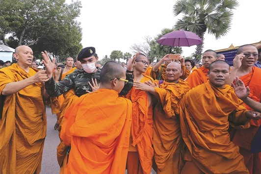 Buddhist monks scuffle with a soldier during a protest against state interference in religious affairs near a temple in Nakhon Pathom province on the outskirts of Bangkok yesterday.