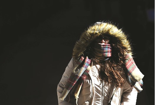 A woman braves the cold weather as she makes her way in downtown Manhattan, New York, on Sunday.