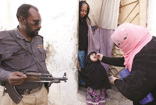 A girl receives polio vaccine drops at the door step of her family home in Karachi, yesterday.