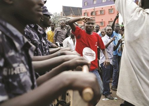 An opposition supporter gestures in front of riot police in Kampala during a protest yesterday.