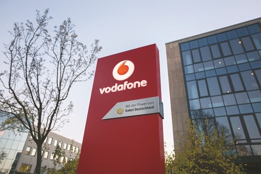 The Vodafone logo is seen on a sign outside the Vodafone Group regional offices in Berlin. Vodafone will pay u20ac1bn in cash to Liberty Global to reflect different valuations of their Dutch units.