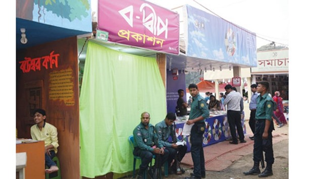 Police stand guard at publisher Shamsuzzoha Maniku2019s stall at a book fair in Dhaka yesterday.