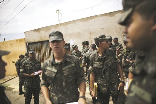 Brazilian soldiers conduct an inspection for the Aedes aegypti mosquito on a street of the Sao Sebastiao neighbourhood in Brasilia, Brazil.