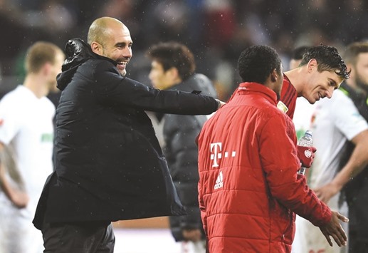 (L-R) Bayern Munichu2019s Spanish headcoach Pep Guardiola jokes with midfielder Douglas Costa and striker Robert Lewandowski after the Bundesliga match against Augsburg.