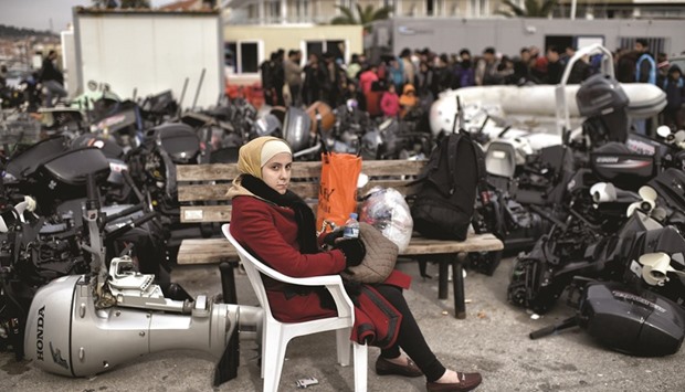 WORN OUT: A migrant sits yesterday among outboard motors in Mytilene as refugees and migrants reach the northern island of Lesbos after crossing the Aegean sea from Turkey.