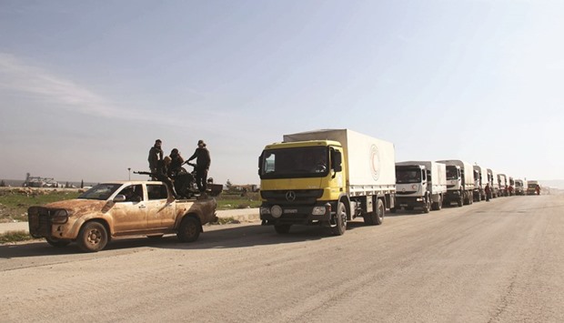 Opposition forces escort a convoy of aid vehicles heading to the government-held Shia towns of Al-Fuaa and Kafraya in Syriau2019s northwestern Idlib province.