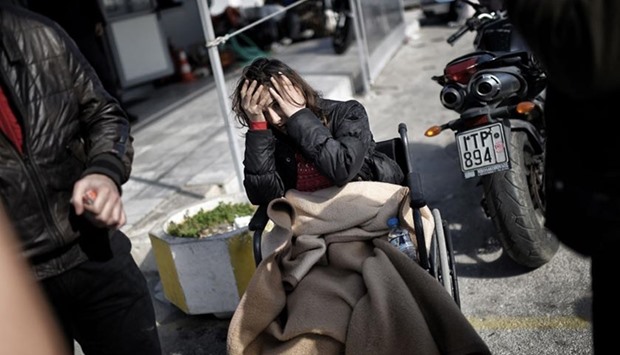 A Syrian Kurdish woman reacts as she waits at the port of the northern island of Lesbos after crossing the Aegean Sea from Turkey, in Mytilene, on Thursday.