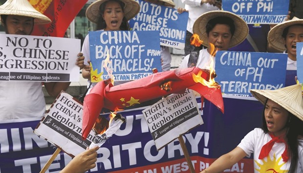 Protesters from the League of Filipino Students and Kabataan (Youth) Party list group burn an effigy symbolising a missile during a rally by more than a dozen students outside the Chinese consulate in Manilau2019s Makati financial district yesterday.