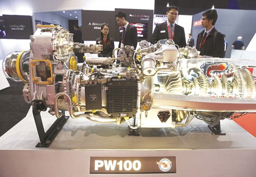 Visitors look at a Pratt and Whitney PW100 engine model at their booth at the Singapore Airshow. Aircraft engine makers are placing bets that could reshape their industry for decades as Boeing weighs a novel design for an airplane with 240-250 seats u2013 a neglected area of the jet market.