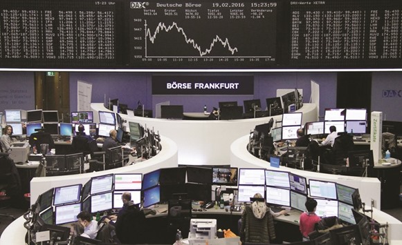 Traders work in front of the DAX board at the Frankfurt Stock Exchange yesterday. The DAX fell 0.8% at 9,388.8 points.