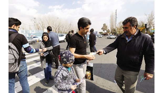 Iranian men hand out campaign leaflets for the upcoming parliamentary elections in Tehran yesterday.
