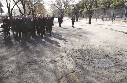 Foreign diplomats and ambassadors walk past the site of the bombing attack in Ankara.