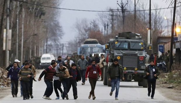 Kashmiri residents run to safety after being rescued from a building taken over by suspected militants during clashes in the Sempora area of Pampore, some 15 kms south of Srinagar. AFP