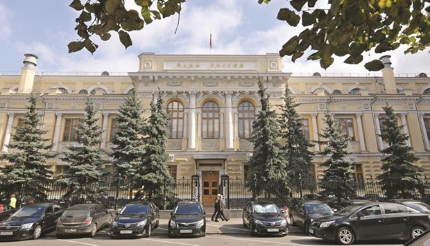 Pedestrians pass the entrance to the headquarters of Russiau2019s central bank. Russia expects to reach its inflation target of 4% by the end of 2017 even if oil prices remain close to current levels, the central bank governor Elvira Nabiullina said yesterday.