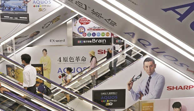 Advertisements for Sharp are seen at an electronics shop in Tokyo. Saddled with debt and struggling with chronic losses, the board of the century-old consumer electronics maker has to decide between Japanese fund INCJu2019s plan to restructure by spinning off businesses or staying as one under a foreign parent with Foxconn.