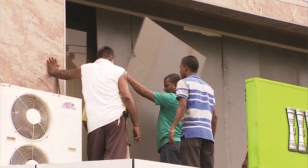 Men board up a shop in preparation for Cyclone Winston in Suva in this still image taken from video.