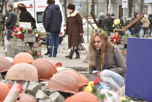 A woman pays her respects at a makeshift memorial in tribute to the slain Maidan activists.