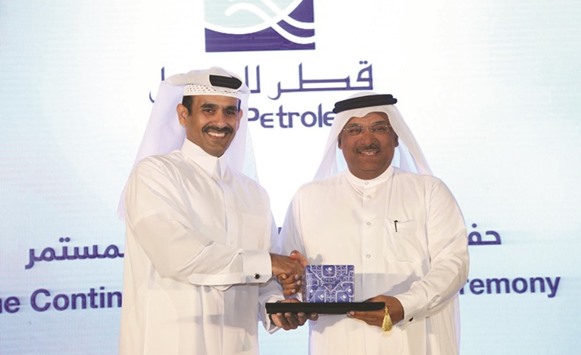 Al-Kaabi (left) honours a senior QP official.