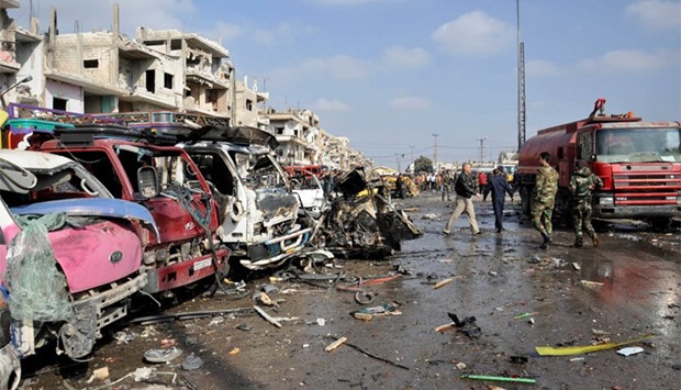 Damaged vehicles at the site of a double car bomb attack in the Al-Zahraa neighborhood of the central Syrian city of Homs.