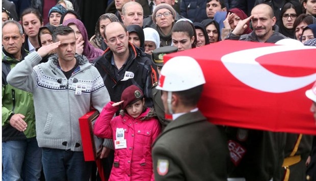 Turkish soldier Dogukan Tazegul's little sister Zeynep Tazegul (centre) salutes her brother's coffin during his funeral at Kocatepe Mosque in Ankara on Sunday. Tazegul and another soldier Enes Demir were both killed on while fighting Kurdish rebels in Sur district, Diyarbakir.