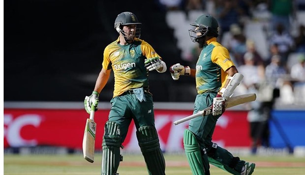 AB de Villiers (left) is acknowledged by Hashim Amla as he leaves the pitch following his dismissal for 71 during the second T20 match against England at the Wanderers Stadium in Johannesburg on Sunday.