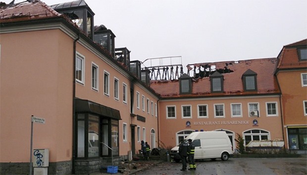 Police and fire fighters stand in front of the former hotel Husarenhof in the eastern German city of