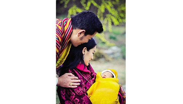 Queen Jetsun Pema holds her newborn son as King Wangchuck looks on.