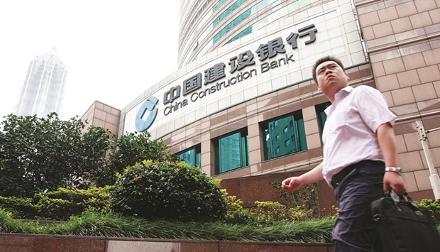 A pedestrian walks past a branch of the China Construction Bank in Shanghai. Chinau2019s second-largest bank by assets is seeking to expand its network to about 40 countries from 24 and increase the overseas contribution of pretax profit to 5% by 2020.