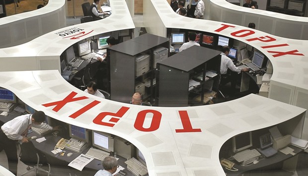 Traders work at the Tokyo Stock Exchange. An equity rout that erased $1.1tn from the Topix index this year prompted investors to park their cash in the relative safety of sovereign securities.