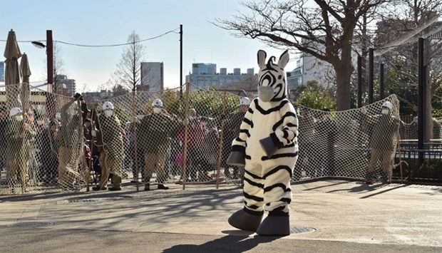 Zookeepers hold a net to capture a zookeeper dressed as zebra during a drill to practice on what to do in the event of an animal escape at the Ueno Zoo in Tokyo on Tuesday.