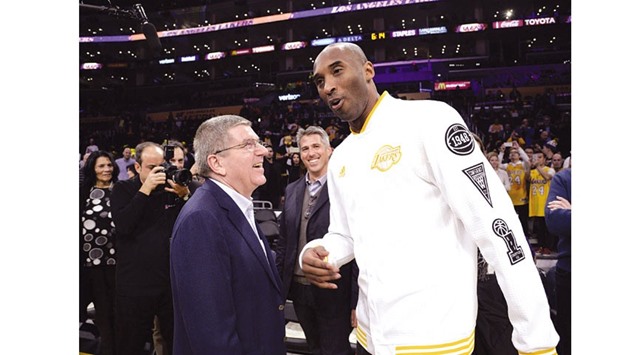 Kobe Bryant (right) of the Los Angeles Lakers greets Thomas Bach, president of the International Olympic Committee during the first half of the basketball game against Charlotte Hornets at Staples Center in Los Angeles, California. Bach wrapped up his tour of the four bid cities for the 2024 Olympic Games with a visit to southern California where he met Monday with Los Angeles Mayor Eric Garcetti. (AFP)