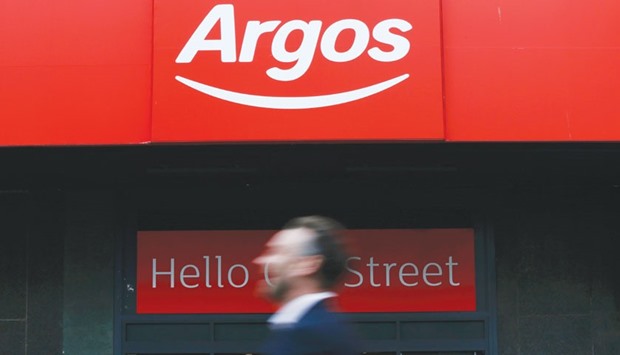 A pedestrian walks past an Argos store in London. Sainsbury will pay about 161.3 pence in cash and stock per Argos-owner Home Retailu2019s share, 63% more than the price prior to the emergence of talks.