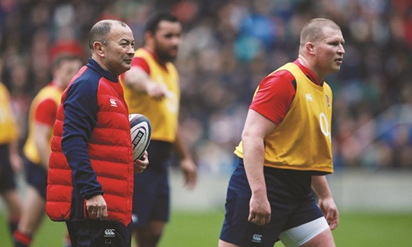 Eddie Jones (L) watches on as England captain Dylan Hartley (R) takes part in a training session at Twickenham.
