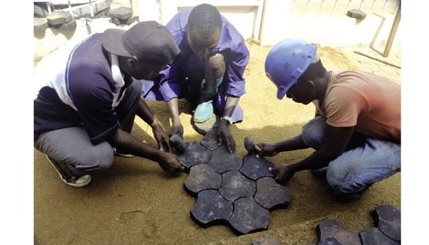 Cameroonian men pave the soil with recycled cobblestones made of plastic waste in Yaounde. The project is a brainchild of Cameroonian great Roger Milla. (AFP)