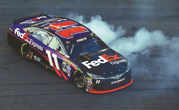 Denny Hamlin, driver of the #11 FedEx Express Toyota, celebrates with a burnout after winning the NASCAR Sprint Cup Series Daytona 500.