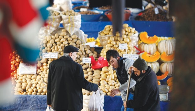 A vendor sells potatoes and other vegetables to a customer in an open market in central Ankara. The IMF said Turkeyu2019s monetary policy framework needs to be improved to strengthen its effectiveness, saying the central bank needs to narrow its interest rate band and provide liquidity at a single policy rate.