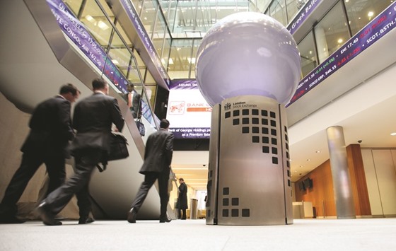 Visitors pass a sign inside the London Stock Exchange. The FTSE 100 closed down 1.2% at 5,962.31 points yesterday.
