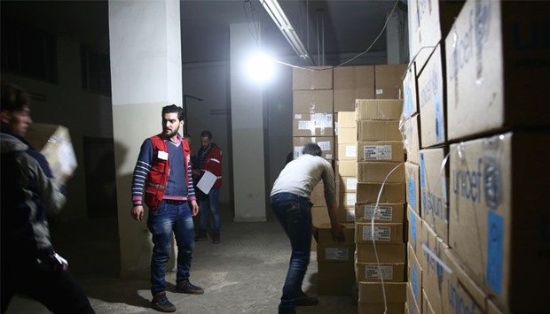 Syrian Red Crescent staff survey the delivery of humanitarian aid at a warehouse in Kafr Batna, in the rebel-held Eastern Ghouta area, on the outskirts of the capital Damascus yesterday. AFP