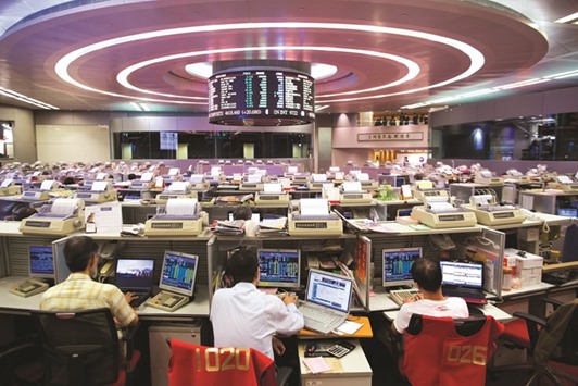 Traders work at the Hong Kong Stock Exchange. The Hang Seng closed down 1.15% to 19,192.45 points yesterday.