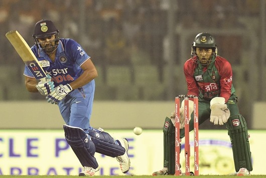 Indiau2019s Rohit Sharma is watched by Bangladesh wicketkeeper Mushfiqur Rahim as he plays a shot during a Asia Cup match at The Sher-e-Bangla National Cricket Stadium in Dhaka yesterday. (AFP)