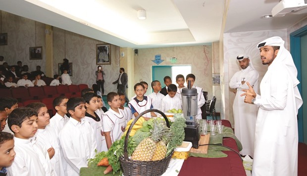 Nutritionists speak to children about the benefits of a healthy diet.