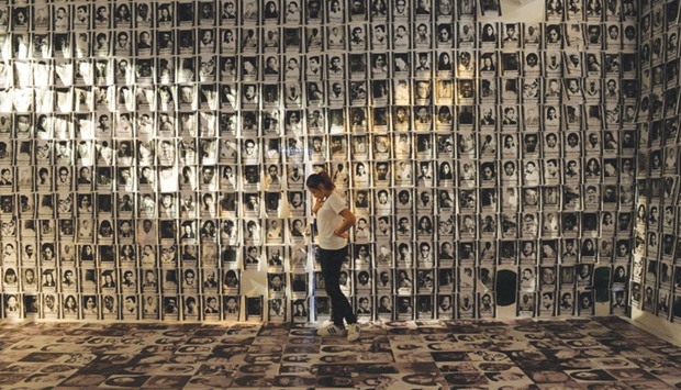 A woman stands among photos taken of human rights victims during martial law, displayed at an experiential museum inside a military camp in Manila yesterday ahead of the 30th anniversary of People Power that toppled dictator Ferdinand Marcos in 1986.