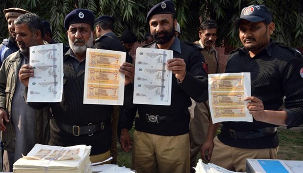 Pakistani police officials display fake currency notes to the media in Lahore on Thursday.