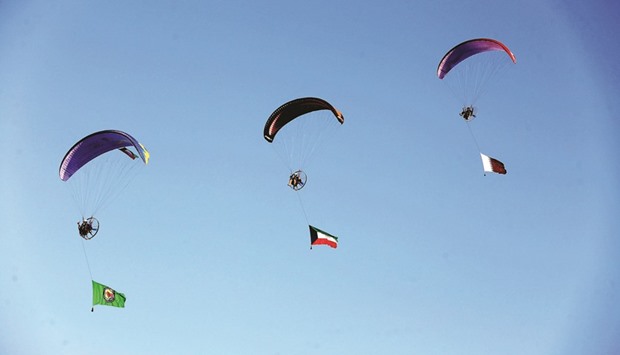 Kuwaiti paragliders decorated with a Qatari, a Kuwaiti and a GCC union flags, fly during celebrations in Kuwait City yesterday marking the Gulf stateu2019s 55th Independence Day and the 25th anniversary of the end of the Gulf war.