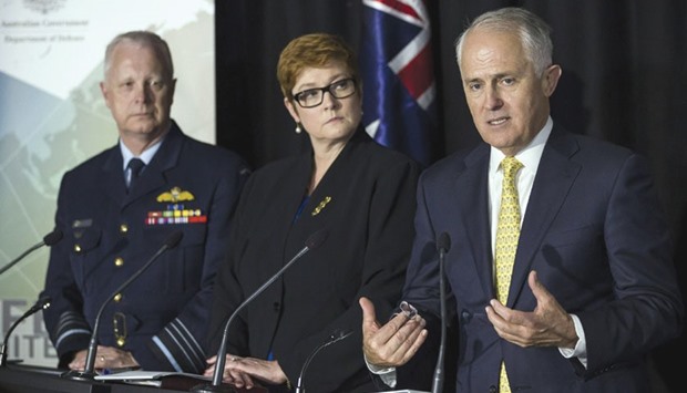 Australiau2019s Prime Minister Malcolm Turnbull (R) speaks to the press after the launch of the 2016 Defence White Paper at the Australian Defence Force Academy as Defence Minister Marise Payne (centre) looks on.