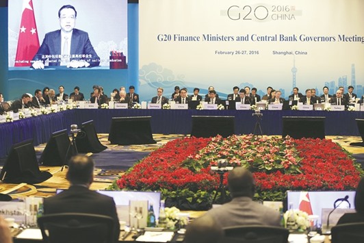 Attendees listen to a speech by Chinese Premier Li Keqiang shown on a screen during the opening ceremony of the G20 finance ministers and central bank governors meeting in Shanghai yesterday. Li urged greater global co-ordination and consideration of policy spillovers.